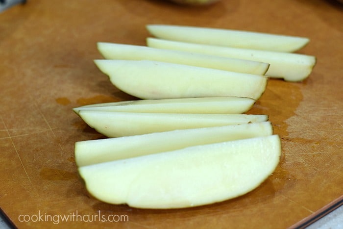 A large potato cut into eight wedges.