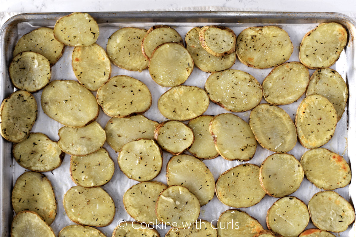 Baked potato slices on a baking sheet. 