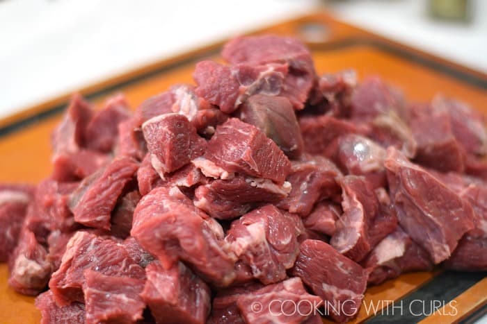 Chuck roast cut into 2 inch pieces on a cutting board