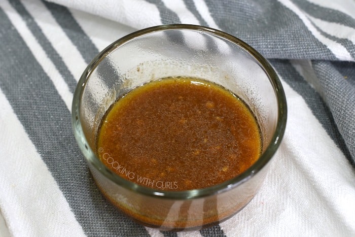 Cooking liquid mixed with thickener in a small glass bowl 