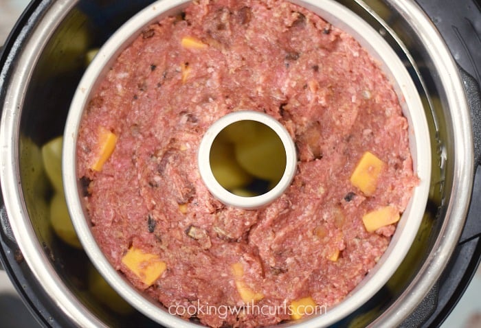 Bacon Cheeseburger Meatloaf in a ring pan over potatoes in an Instant Pot.