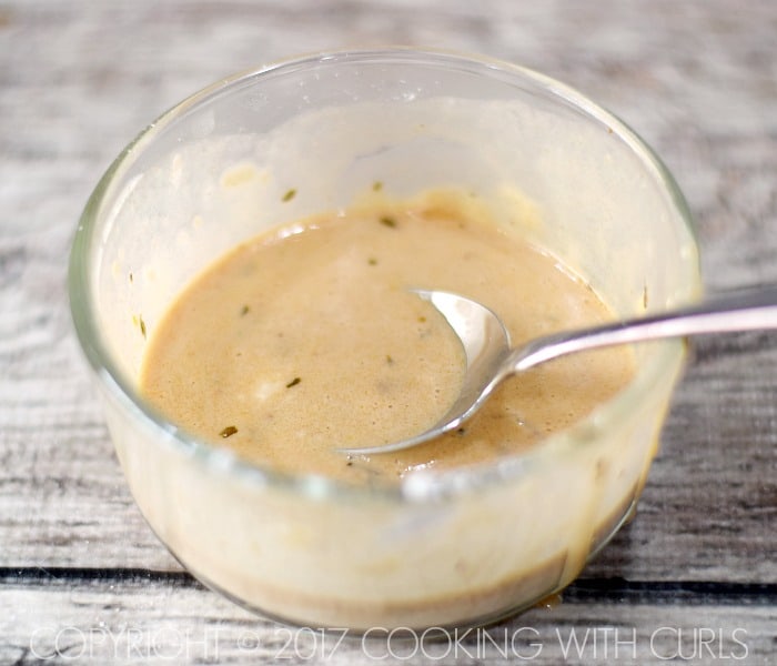 corn starch and cooking liquid mixed together in a small glass bowl to create a slurry.