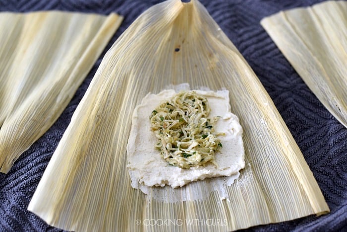 Salsa Verde Chicken in the center of the masa square on the corn husk. 