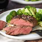 sliced filet mignon on a white plate with broccoli florets, with a second plate in the background and title graphic across the top.