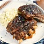 Instant Pot Pork Ribs on a a white plate with cauliflower rice with a small bowl of teriyaki sauce in the upper right hand corner